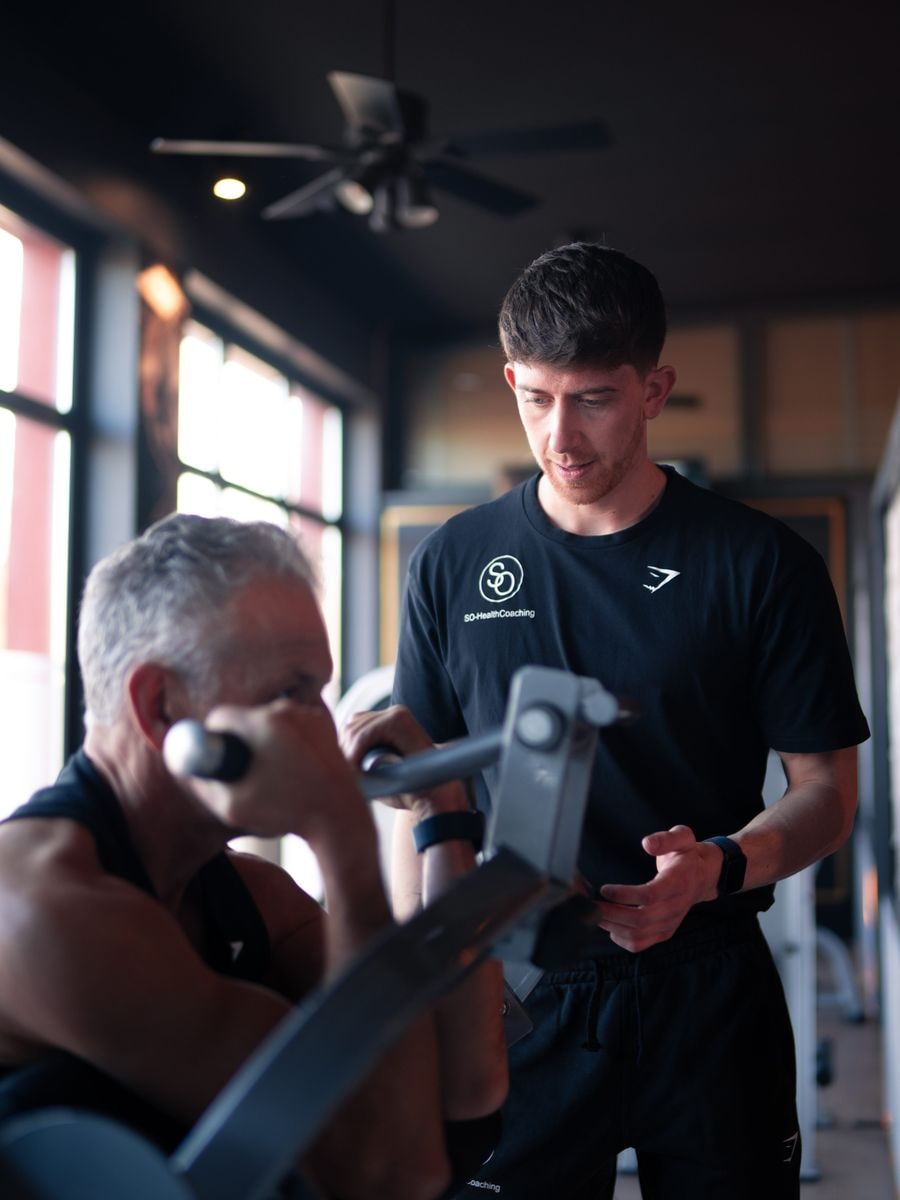 Personal Coach Sven betreut einen Teilnehmer beim Krafttraining im GymOne Bitburg